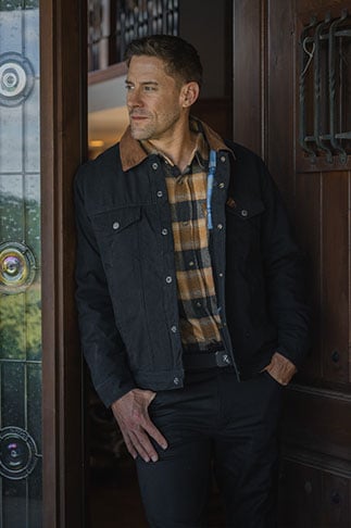 Man standing in doorway wearing a Legendary Whitetails jacket