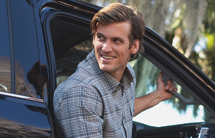 Man getting out of a care wearing Men’s Textured Stretch Woven Plaid Short Sleeve Shirt from Legendary Whitetails